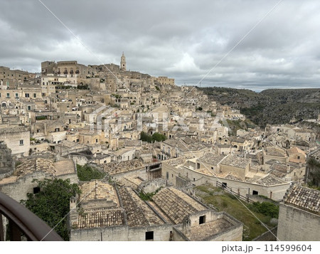 ドゥオーモの尖塔を見るマテーラ洞窟住居群風景 114599604