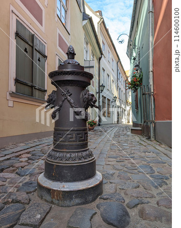 Bollard to restrict the movement of cars, decorative column on sidewalk of city street. The pole are on a on footpath in old town of Riga, Latvia. Bollard to restrict the movement of cars, decorative column on sidewalk of city street. The pole are on a on footpath in old town of Riga, Latvia. 114600100