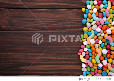 Colorful lollipops and different colored round candy on brown wooden background 114600706