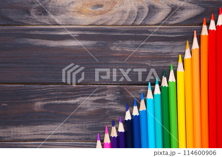 Many different colored pencils on brown wooden background Many different colored pencils on brown wooden background 114600906