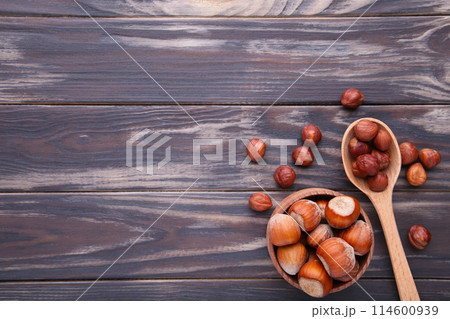 Delicious hazelnut in the wooden bowl and spoon on brown background Delicious hazelnut in the wooden bowl and spoon on brown background 114600939