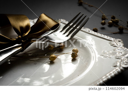 Romantic tabble setting with ribbon, plates, cutlery on black background. Empty plate. Mockup design layout for your text. Love romantic concept. Copy space. Top view. Flat lay. Romantic tabble setting with ribbon, plates, cutlery on black background. Empty plate. Mockup design layout for your text. Love romantic concept. Copy space. Top view. Flat lay. 114602094