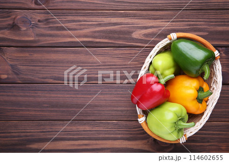 Colorful pepper in a basket on a brown background. Colorful pepper in a basket on a brown background. 114602655