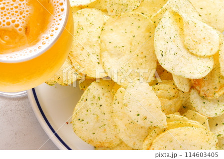 のり塩味のポテトチップスと、よく冷えたビールのグラス のり塩味のポテトチップスと、よく冷えたビールのグラス 114603405
