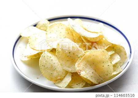 お皿に山盛りの、のり塩味のポテトチップス 114603510