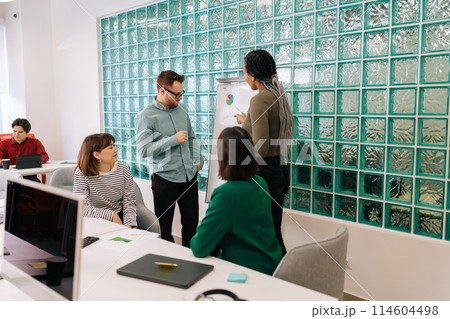 Modern corporate office open space with busy male and female staff employees using laptop computers sitting at work in big modern corporate office. Startup team working together at creative open space 114604498