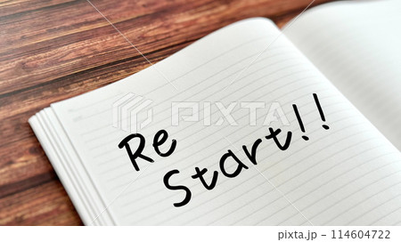 ReStart!!の文字入り開いたノートクローズアップ_茶板背景 114604722
