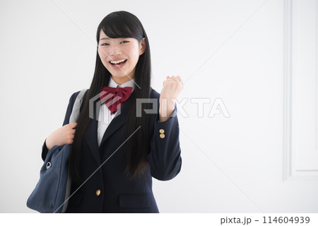 使いやすい白背景で正面を向き笑顔のガッツポーズする女子高生 右にコピースペースあり 受験合格するぞ 114604939