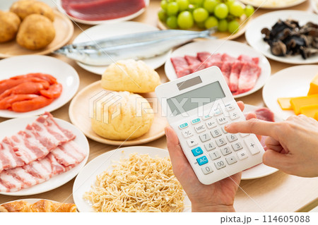 電卓を持つ女性の手元と色々な食材 電卓を持つ女性の手元と色々な食材 114605088