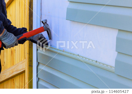 Plastic siding replacement on house exterior wall Plastic siding replacement on house exterior wall 114605427