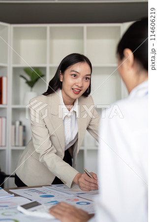Young businesswoman presenting financial data in a modern office. Concept of leadership, strategy, and professional growth 114606219