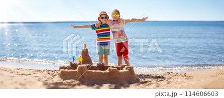 Boy and girl building on the beach sandcastle. 114606603