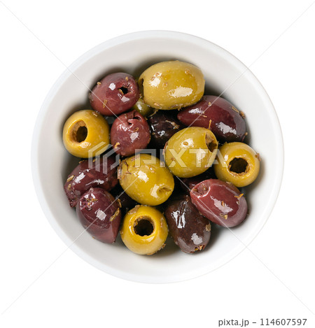Pitted Kalamata and green olives, in a white bowl. Mix of organic green and black Greek olives with herbs, preserved in native olive oil. Popular table olives, used as snack, appetizer or as garnish. 114607597