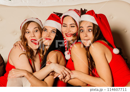Four pretty women with curly hair and red Christmas lingerie. New year background. Four pretty women with curly hair and red Christmas lingerie. New year background. 114607711