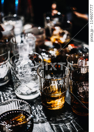 Whiskey Cocktail with Ice Sphere in a Moody Bar Setting 114607777