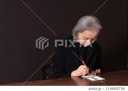 喪服のシニア女性　香典 114608736