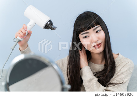 ドライヤーを使う若い女性 114608920