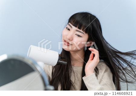 ドライヤーを使う若い女性 114608921