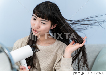 ドライヤーを使う若い女性 114608924