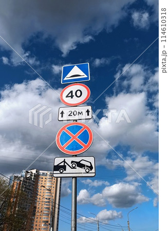 Traffic signs on the background of blue sky with white clouds. Traffic signs on the background of blue sky with white clouds. 114610318