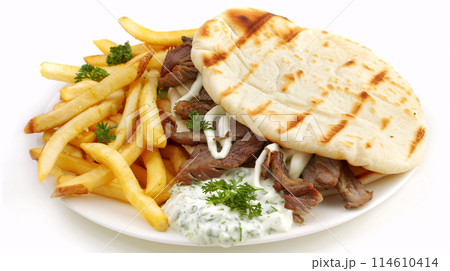 an artisan juicy gyros with sauce, surrounded by golden and french fries on a white background 114610414