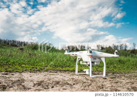 white quadrocopter standing on the ground white quadrocopter standing on the ground 114610570