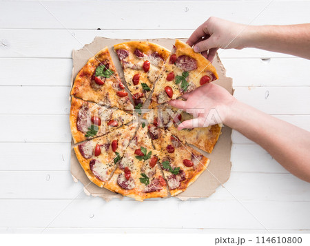 hands taking a portion of delicious pizza 114610800
