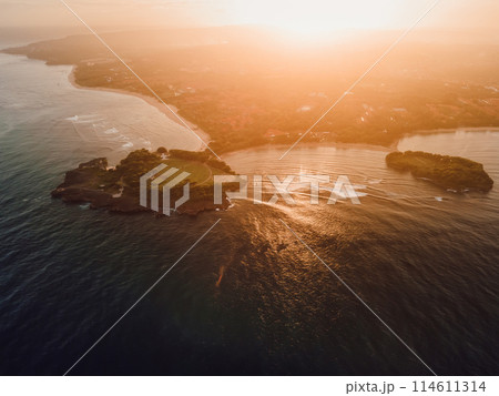 Coastline with islands, warm sunset tones and ocean in Nusa Dua, Bali Coastline with islands, warm sunset tones and ocean in Nusa Dua, Bali 114611314