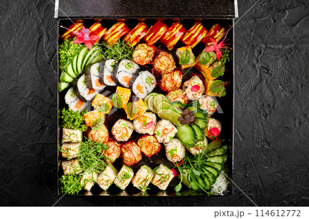 Delightful sushi roll set with fresh garnishes in black box 114612772