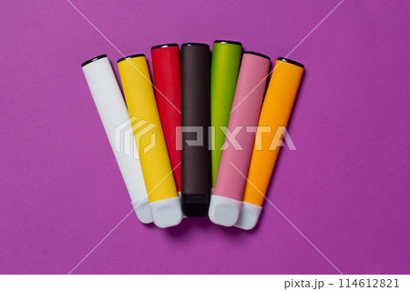 Set of colorful disposable electronic cigarettes on a purple background. The concept of modern smoking, vaping and nicotine. Top view Set of colorful disposable electronic cigarettes on a purple background. The concept of modern smoking, vaping and nicotine. Top view 114612821