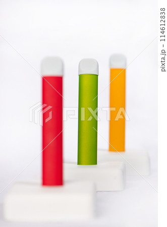 Set of colorful disposable electronic cigarettes on a display stand on a white background. The concept of modern smoking, vaping and nicotine. Set of colorful disposable electronic cigarettes on a display stand on a white background. The concept of modern smoking, vaping and nicotine. 114612838