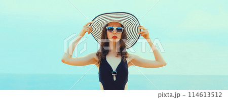 Summer vacation, beautiful young woman in bikini swimsuit and straw hat on the beach at sea 114613512