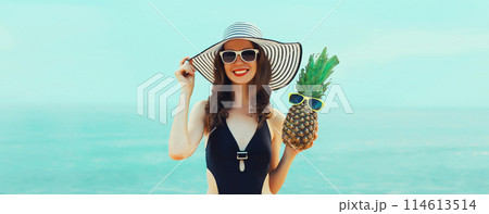 Summer vacation, beautiful happy woman in bikini swimsuit, hat, pineapple fruits on the beach at sea Summer vacation, beautiful happy woman in bikini swimsuit, hat, pineapple fruits on the beach at sea 114613514