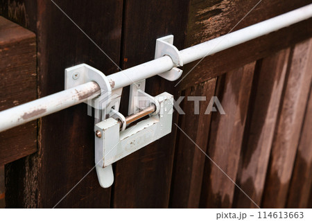 Old Japan style lock on the door. lock on the wooden door close-up. Traditional Japanese lock hanging on the wooden door. 114613663