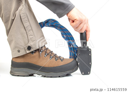 trekking boots for hiking next to a climbing rope and a knife on a white background 114615559