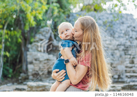 Mother and son tourists at Coba, Mexico. Ancient mayan city in Mexico. Coba is an archaeological area and a famous landmark of Yucatan Peninsula. Cloudy sky over a pyramid in Mexico 114616048