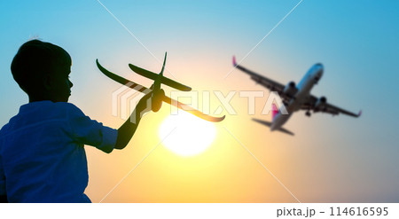 Silhouette of a boy launches a model airplane into the sky against the backdrop of the setting sun. Silhouette of a boy launches a model airplane into the sky against the backdrop of the setting sun. 114616595