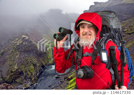 happy bearded man traveler with hiking equipment on mountain landscape background. 114617330