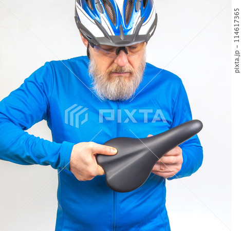 male cyclist checks the softness of his bicycle saddle. sports and transport equipment 114617365