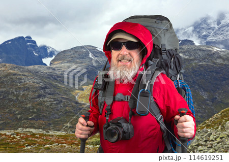 happy bearded man traveler with hiking equipment on mountain landscape background happy bearded man traveler with hiking equipment on mountain landscape background 114619251