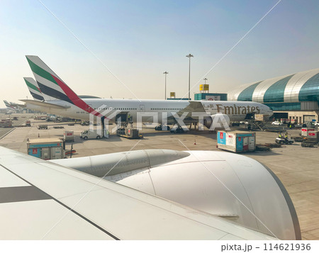 ドバイ空港ターミナルと出発準備中のエミレーツ航空機 114621936