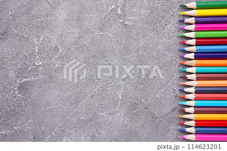 Many different colored pencils on grey concrete background 114623201