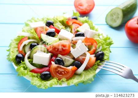 Fresh vegetable salad with fork and vegetable on blue wooden background 114623273