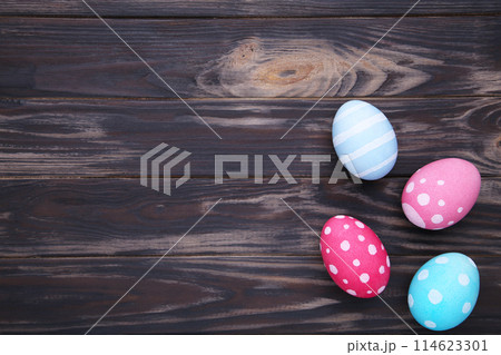 Colorful easter eggs on a brown wooden background Colorful easter eggs on a brown wooden background 114623301