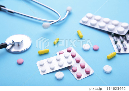 Stethoscope with pills on blue background. Top view with place for your text. 114623462