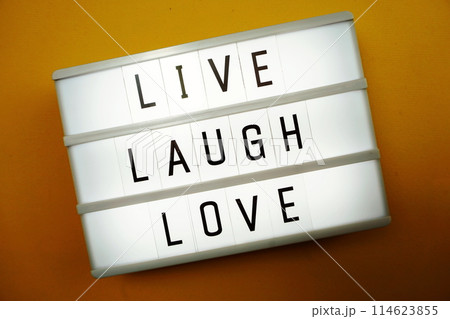 Live Laugh Love word in light box flat lay on yellow background Live Laugh Love word in light box flat lay on yellow background 114623855