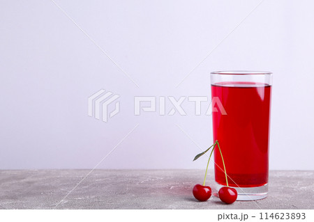 Glass of cherry juice and berries on grey background with copy space 114623893