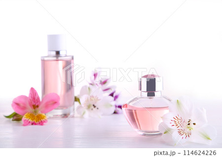 Perfume bottles with flowers on white background, top view Perfume bottles with flowers on white background, top view 114624226