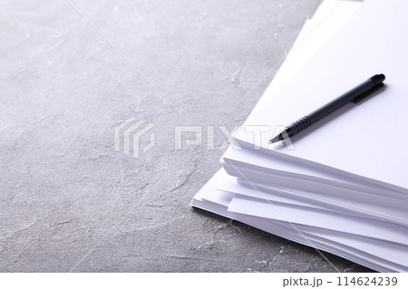 Stack white paper with pen on grey concrete background with Clipping Path Stack white paper with pen on grey concrete background with Clipping Path 114624239