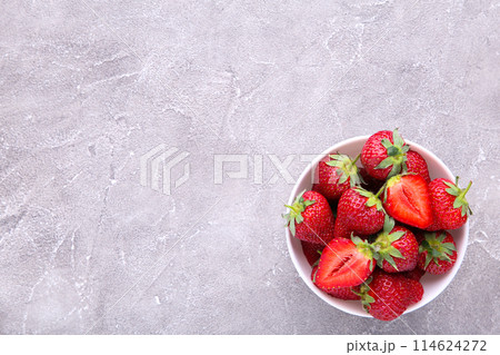 Strawberries in bawl on grey concrete background Strawberries in bawl on grey concrete background 114624272
